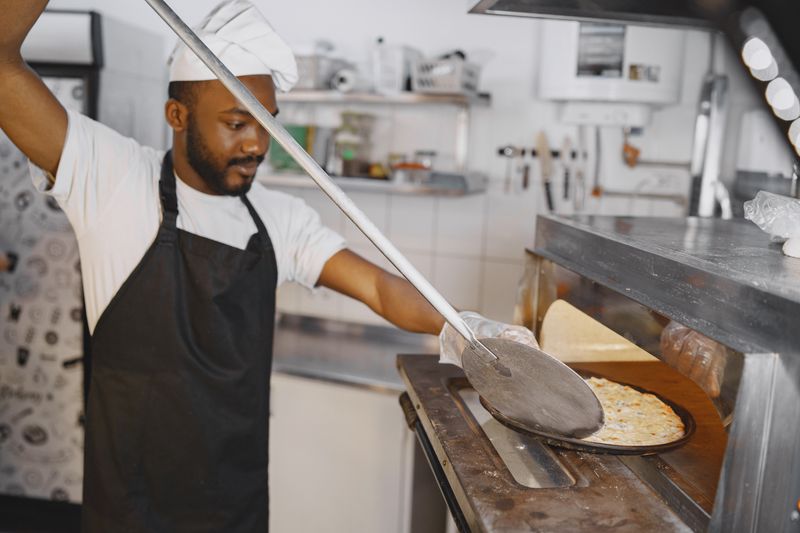 Fresh pizza coming out of the oven at Pizza factory
